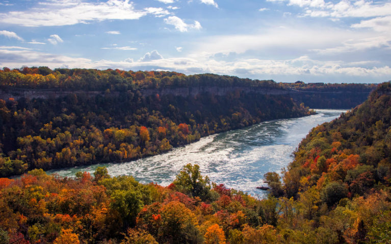 Scenic view of the Niagara Glen along the Niagara River in autumn, with colourful fall foliage and cliffs.