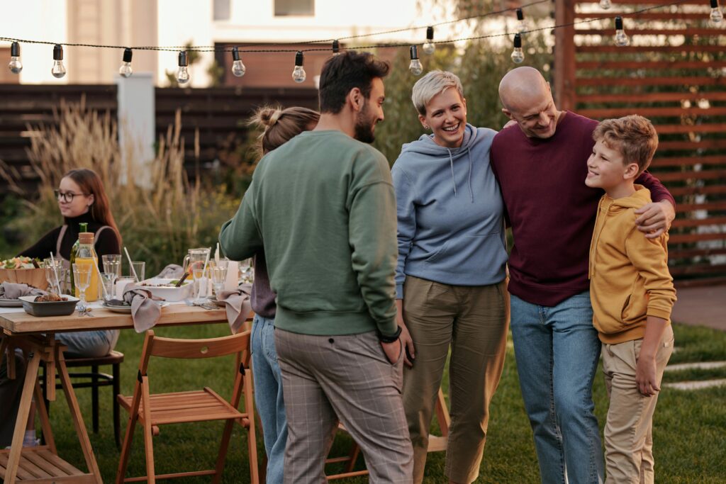 Family and friends enjoying a backyard gathering with food and drinks, representing how buying a home is about lifestyle as well as the property itself.