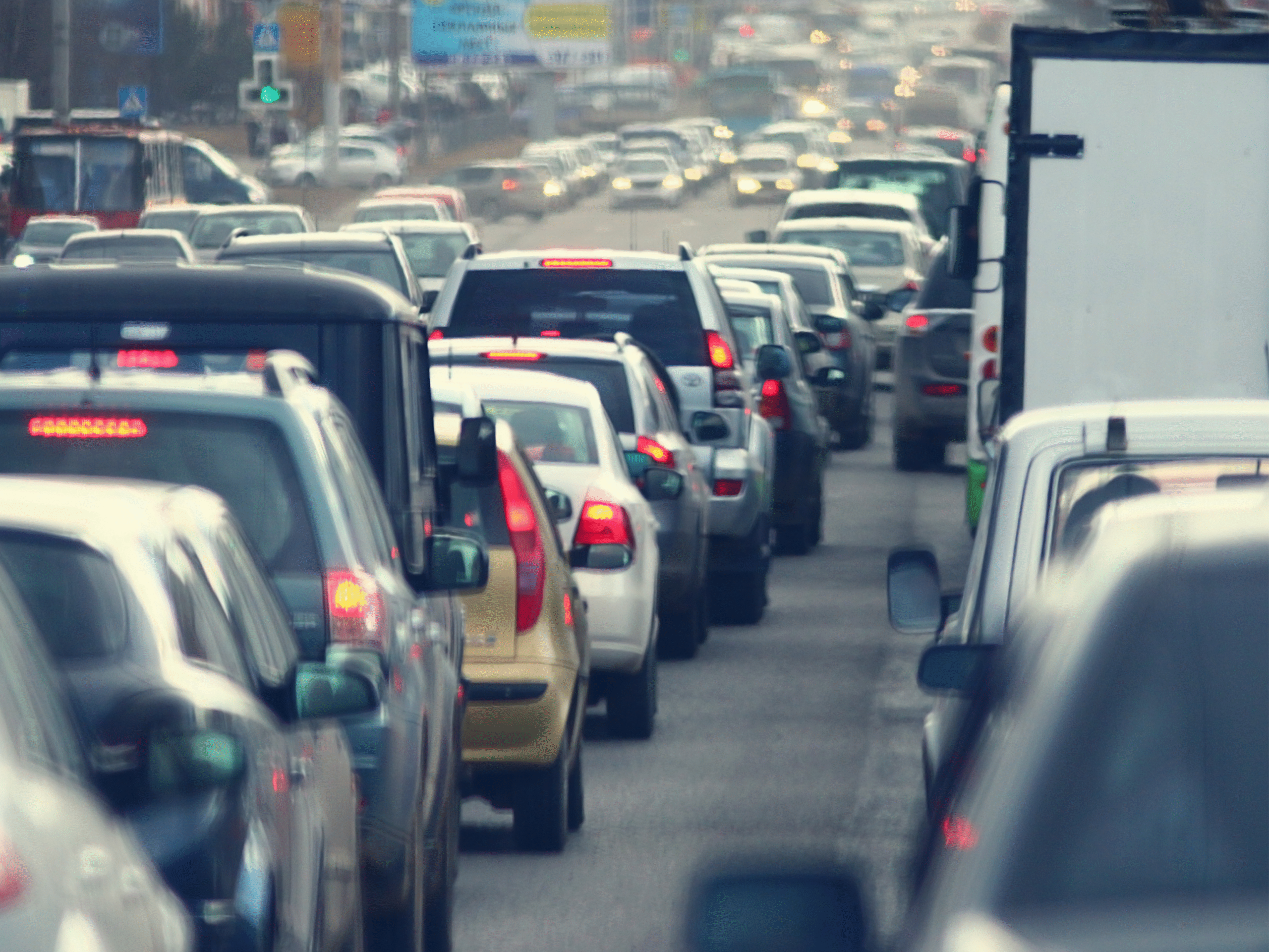 Line of cars stuck in heavy traffic on a busy Toronto roadway during rush hour.